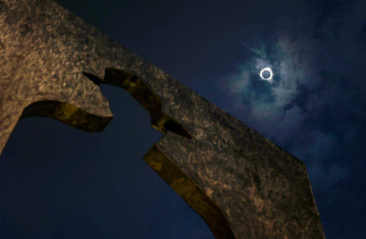 The total eclipse of the sun over downtown Fort Worth’s Burnett Park, with the Man with a Briefcase statue in the foreground, on Monday, April 8, 2024.