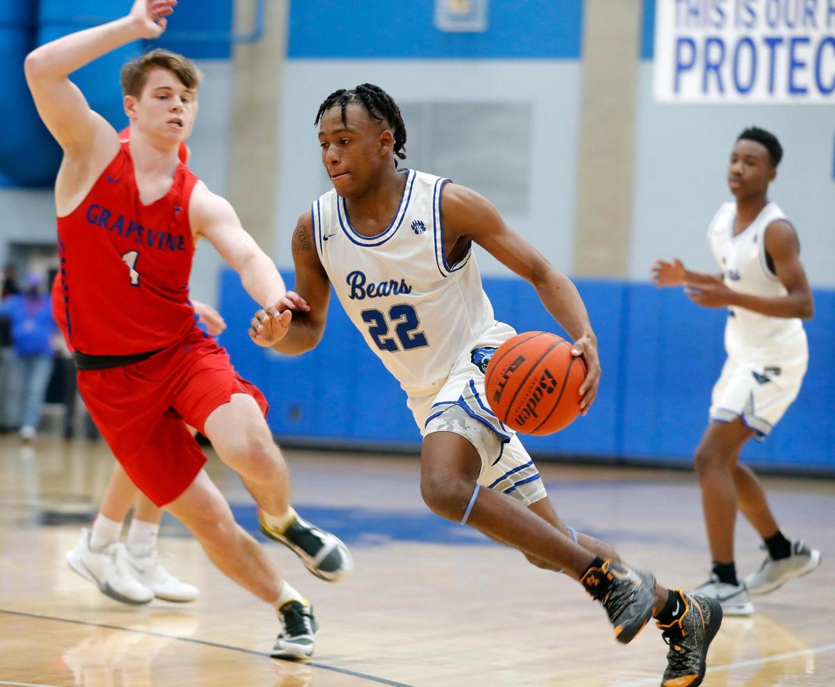 Brewer guard BJ Williams (22) drives into the key ahead of Grapevine point guard Jackson Waggoner (1) during the first half of a 5A Region 1 bi-district basketball game at Brewer High School in Fort Worth, Texas, Monday, Feb. 22, 2021. Grapevine led Brewer by two at the half. (Special to the Star-Telegram Bob Booth)