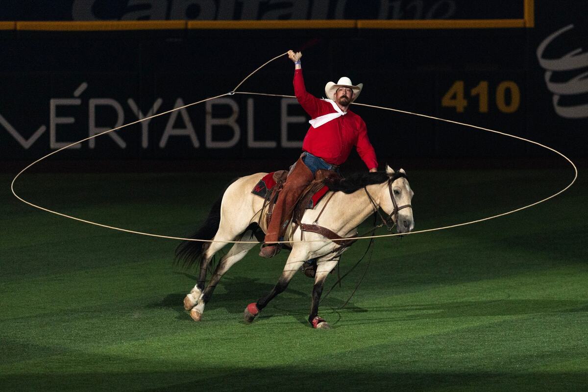A cowboy uses his lasso in the pregame ceremony prior to the MLB All Star Game at Globe Life Field in Arlington on Tuesday July 16, 2024.