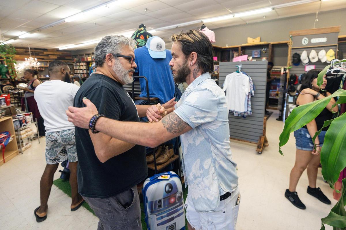 Josh Santillan, the director of Central Arts, left, greets nonprofit director Ryan Martinez in his store called The Awareness Project in Hurst in June. The nonprofit is scheduled to close later this summer due to rising rent costs.