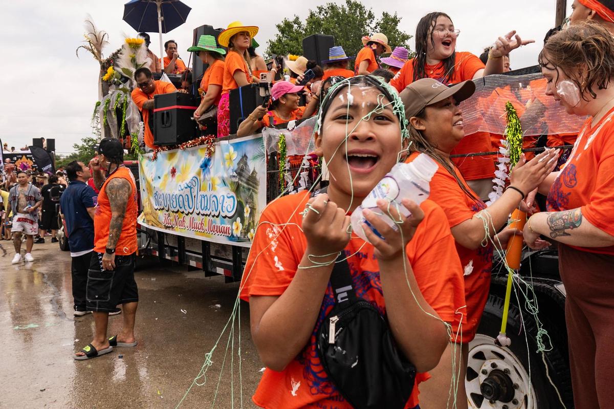 A festival attendee becomes covered in silly string during the Lao New Year parade on the third day of the Lao New Year festival at Wat Lao Thepnimith Temple in Saginaw on Sunday, April 27, 2025.