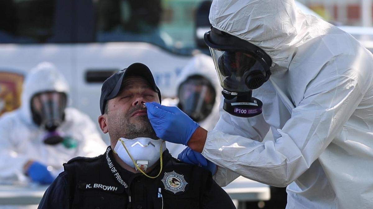 In this May 2020 file photo, correctional officer Kerry Brown is tested for COVID-19 by a Fort Worth firefighter near Federal Medical Center prison in Fort Worth.