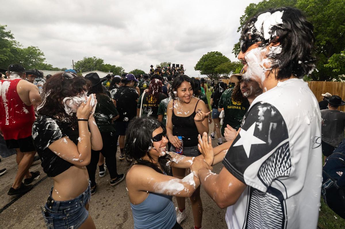 Festival attendees rubs shaving cream on each other during the Lao New Year parade on the third day of the Lao New Year festival at Wat Lao Thepnimith Temple in Saginaw on Sunday, April 27, 2025.