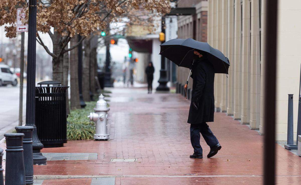 A person walks along 3rd Street as freezing rain falls across the region Wednesday, Feb. 23, 2022, in downtown Fort Worth.