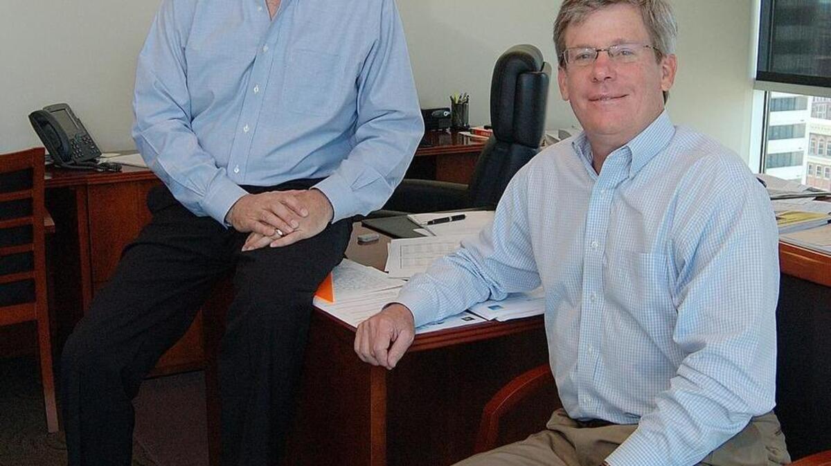 John Pinkerton, right, shown with Jeff Ventura when the company announced Ventura’s promotion to CEO in 2011.
