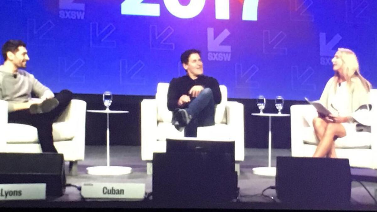 Mark Cuban, center, flanked by Adam Lyons and Michele Skelding, on the screen at a SXSW Interactive talk Sunday.