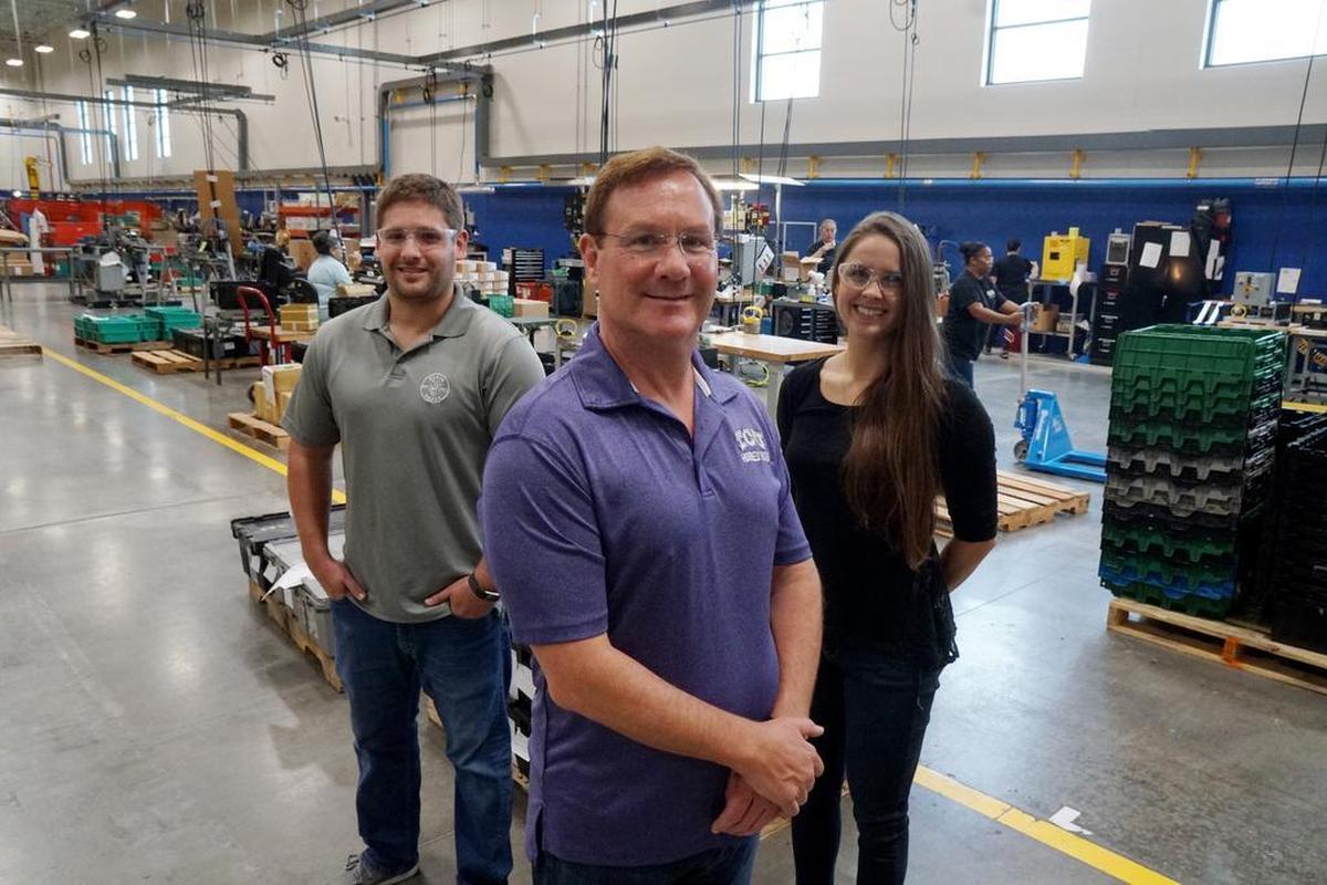 Tom Klein Sr., his son David J. Klein, and daughter Leah Klein Fox stand on the floor at Klein Tools in Mansfield.