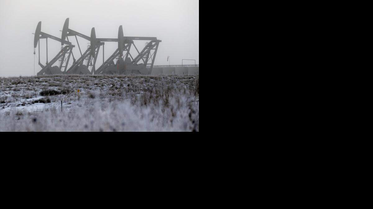 
Oil pump jacks work in unison on a foggy morning in Williston, N.D. 
