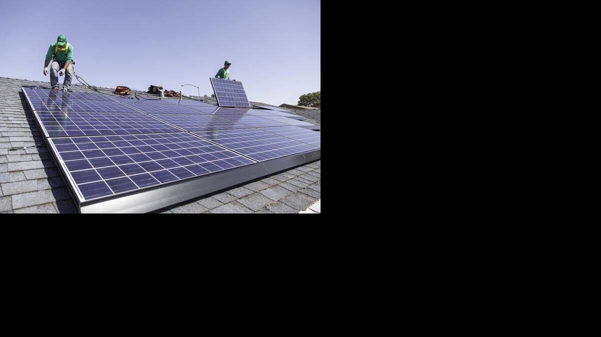 
In this undated photo provided by SolarCity, workers install solar panels on the roof of a home. 
