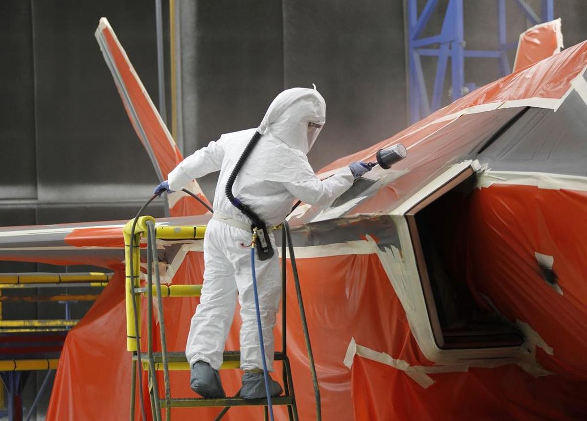 A painter sprays coatings on a F-35 fighter jet in the finishing area at Lockheed Martin Aeronautics in Fort Worth.