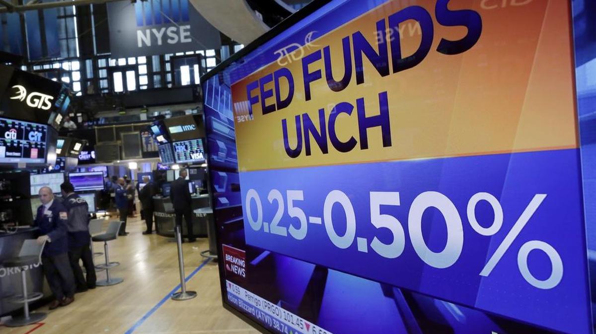 A television screen on the floor of the New York Stock Exchange shows the Federal Reserve's decision to keep interest rates unchanged.