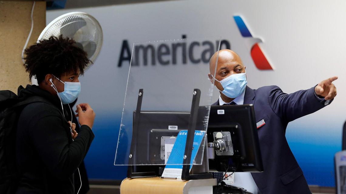 An American Airlines agent points out directions after checking in a passenger at Dallas Fort Worth International Airport in 2021.