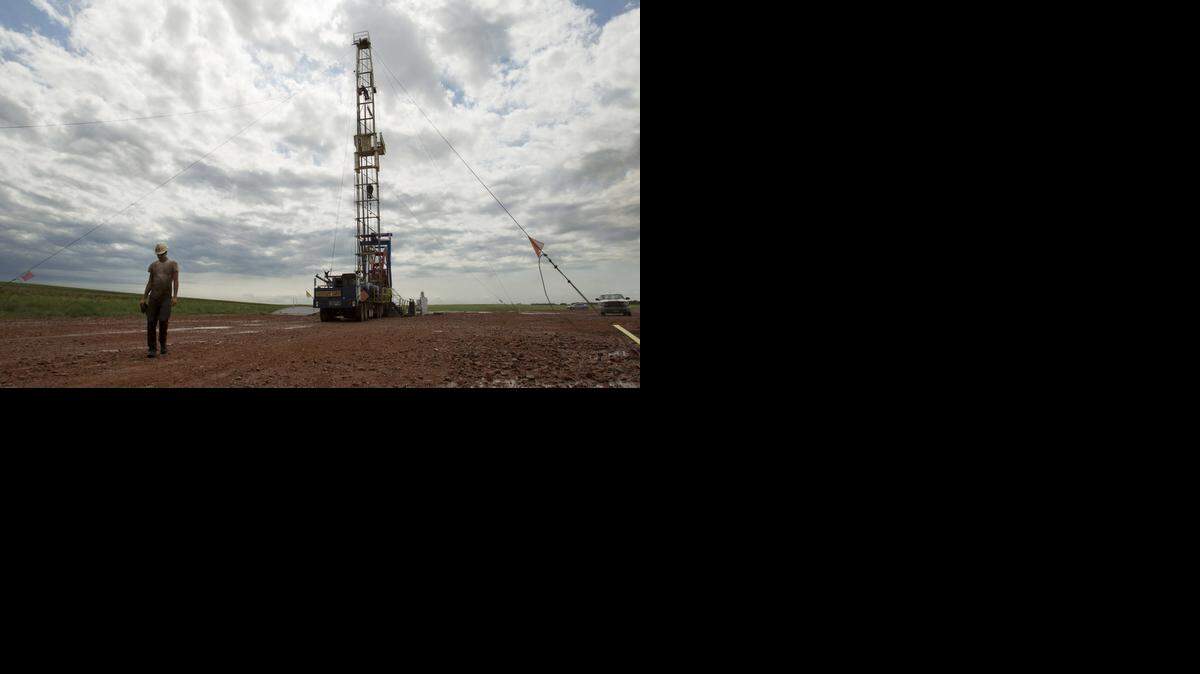 
Lower oil prices, while good for the broader U.S. economy, are a threat to what has been a surprising and dramatic surge in oil production in the U.S., and to drilling communities that have come to depend on oil money. In this Tuesday, July 2011 file photo, Austin Mitchell walks away from an oil derrick outside of Williston, N.D.



