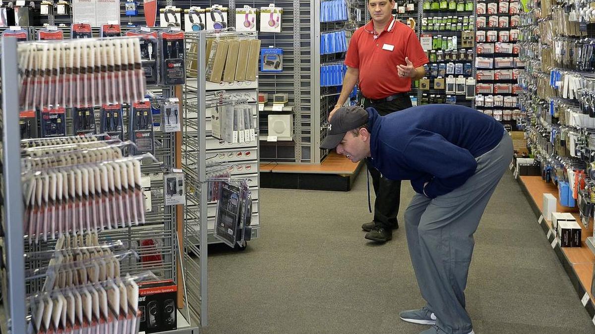 Store manager Jeremia Mcelveen helps a customer at revamped RadioShack store, which has Sprint wireless store inside.
