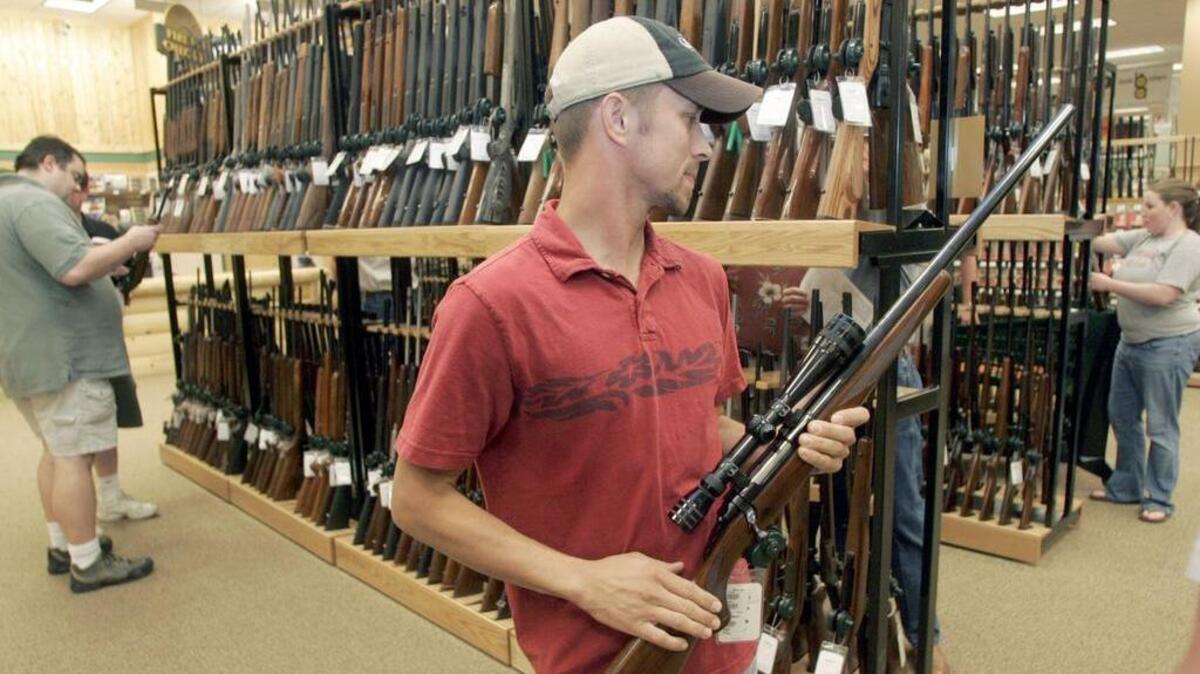 Customer checks out a rifle at Cabela’s.
