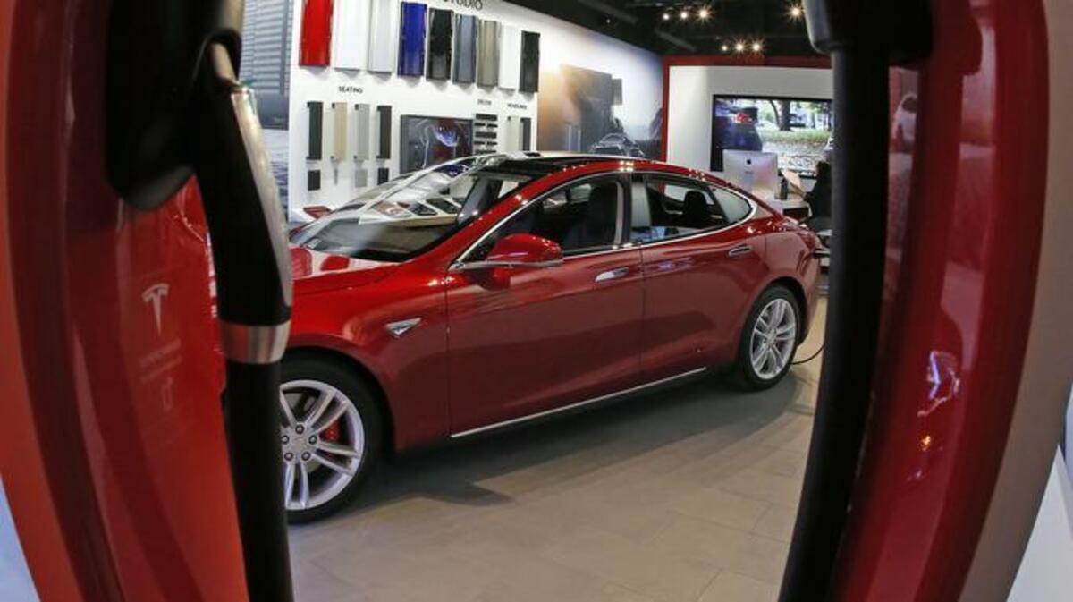 A charging station frames the showroom Tesla on display. On Thursday the automaker announced production of a $35,000 version of the car.