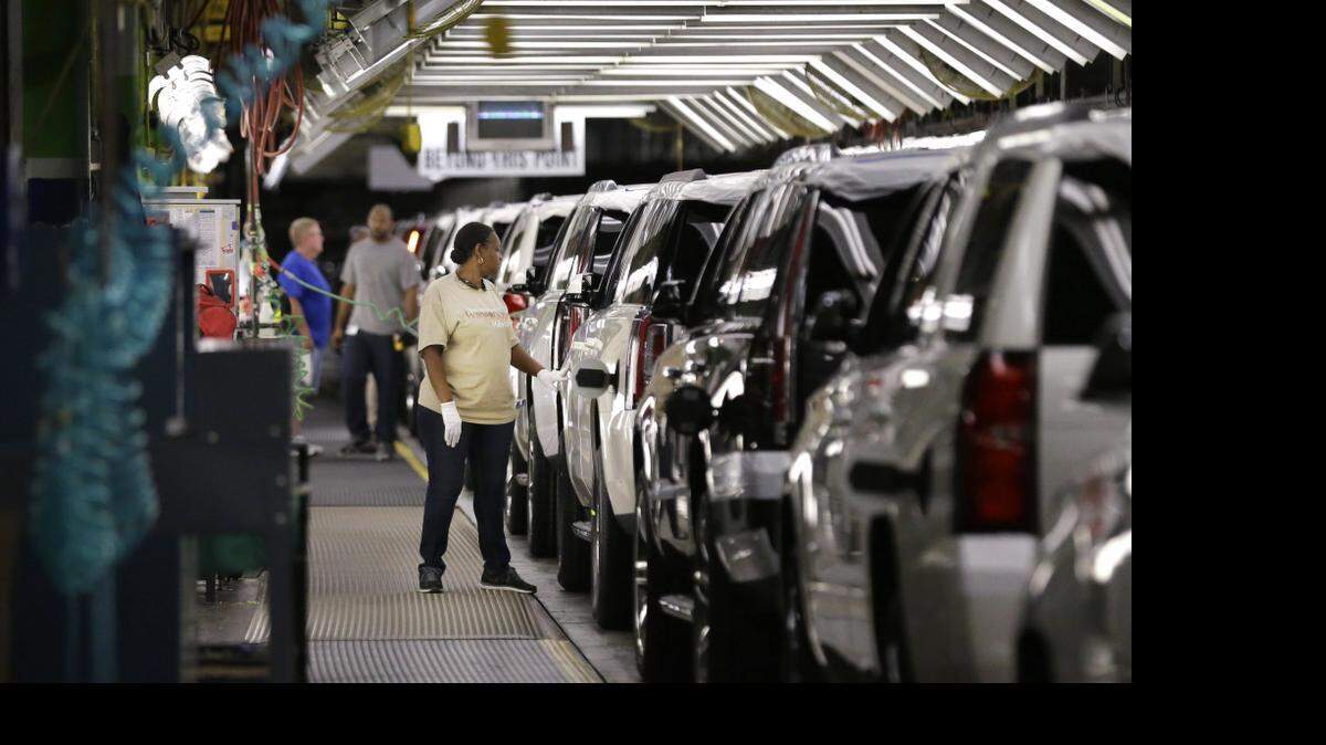 
An auto worker inspects finished SUVs coming off the assembly line at the General Motors auto plant in Arlington. The company sold nearly 55,000 big SUVs, the best January-through-March period in seven years.

