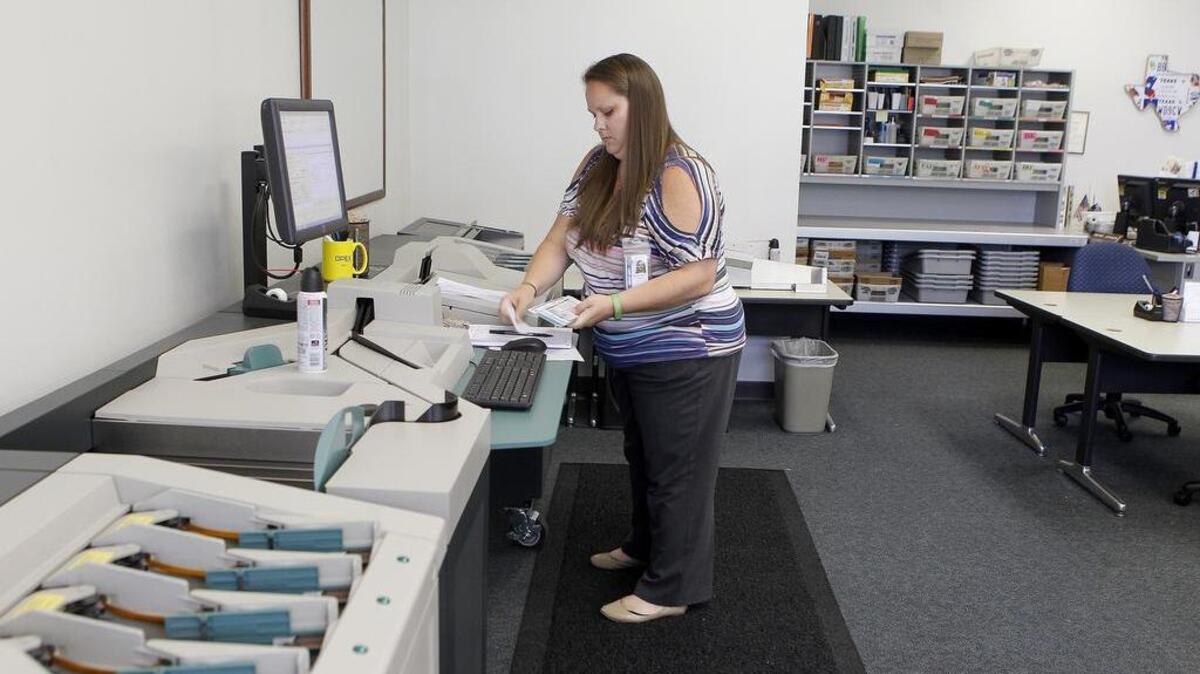 Mandi Chance scans in property tax payments at the Tarrant County Administration Office in Fort Worth.