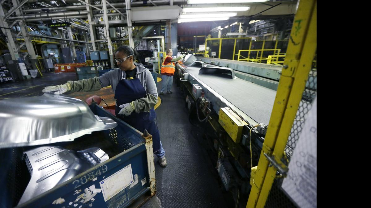 
Line worker Michelle Albritton loads stamped wheel housings at the General Motors Pontiac Metal Center, one of several plants getting $5.4 billion in new investment. 
