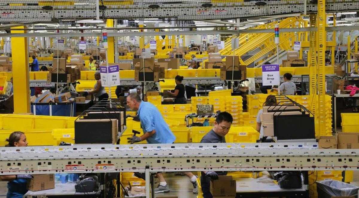 Associates prepare boxes for shipping at the sprawling Amazon fulfillment center in Haslet.