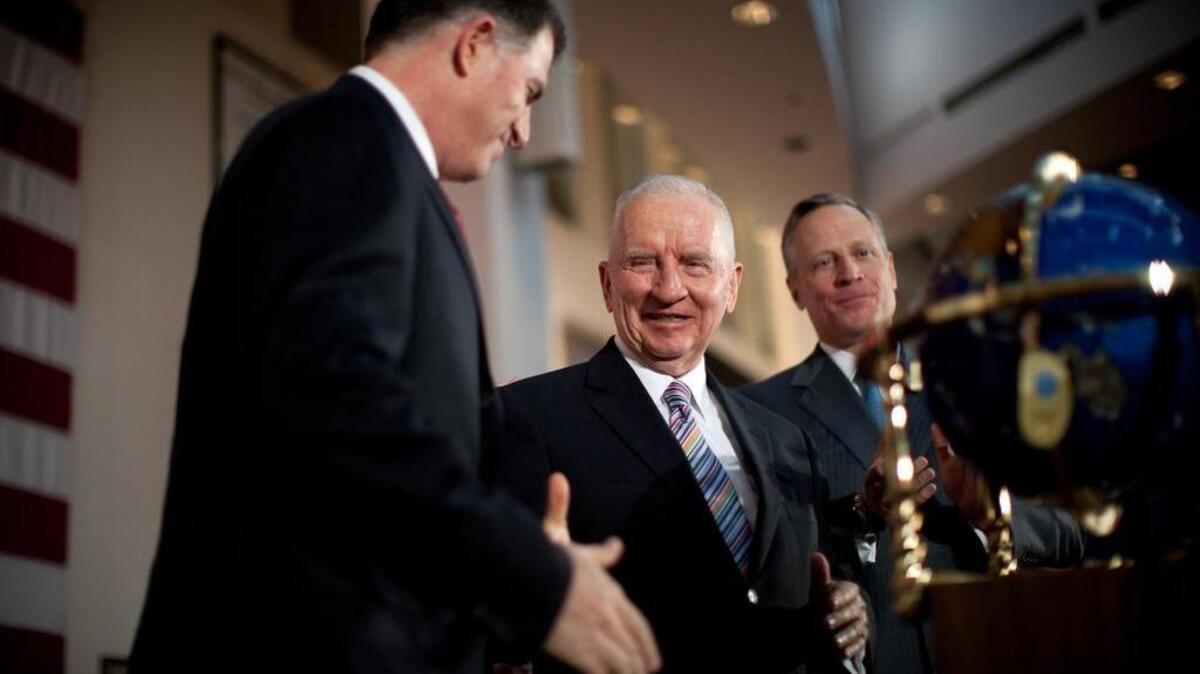 Michael Dell and Ross Perot Sr. shaking hands as in September 2009 as Dell agreed to acquire Perot Systems for $3.9 billion.