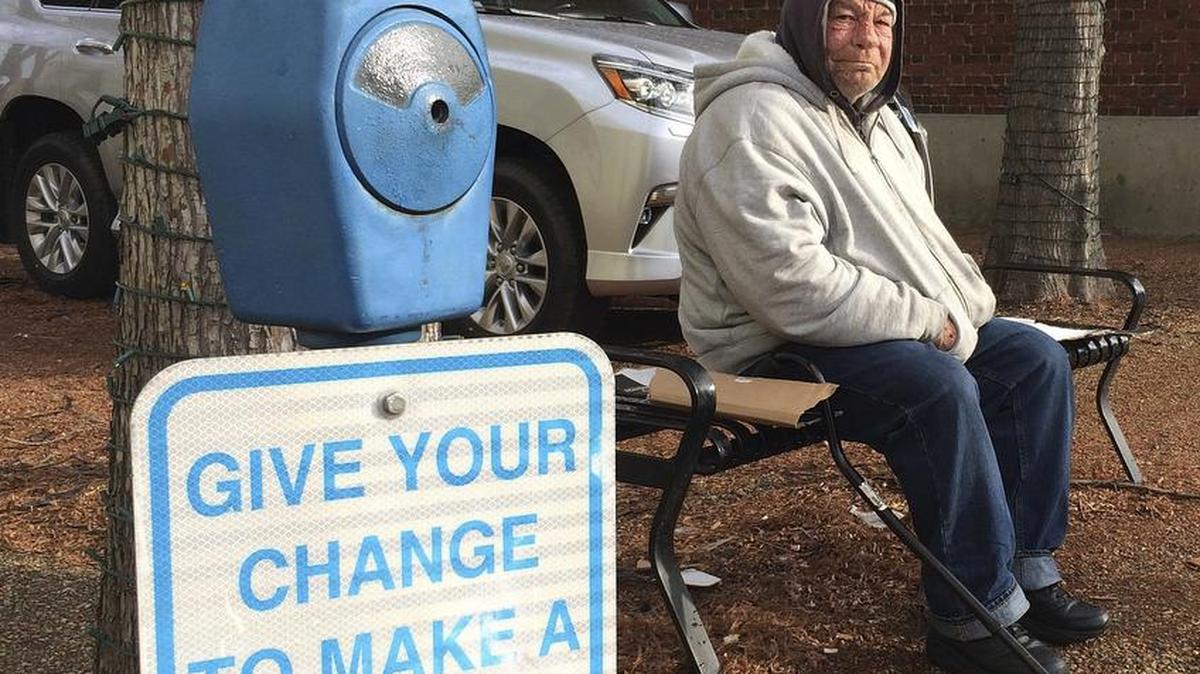Joe Drury, who said he is homeless, sits near a parking-style meter in Annapolis, Md., used to collect loose change from those who might otherwise give money to those begging on the street.