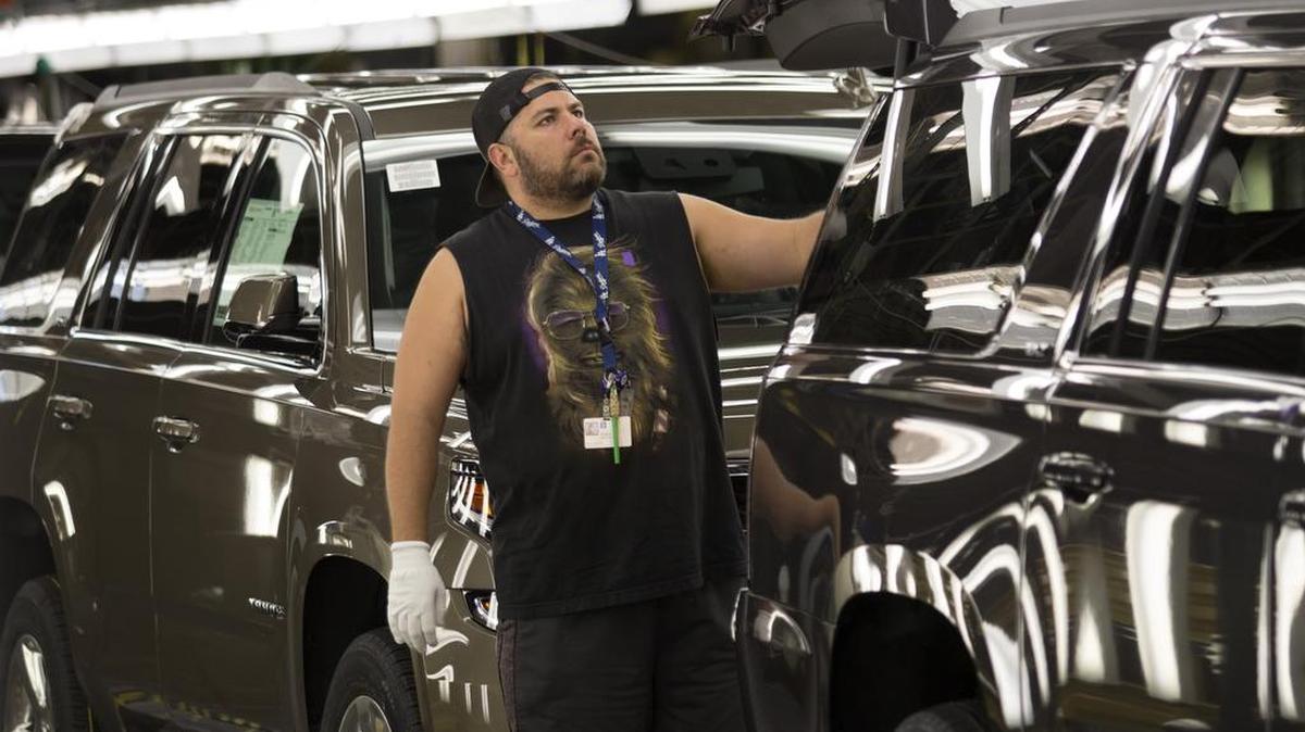 
GM employee Efren Martin II checks vehicles for flaws in the final line at GM July 2015. 
