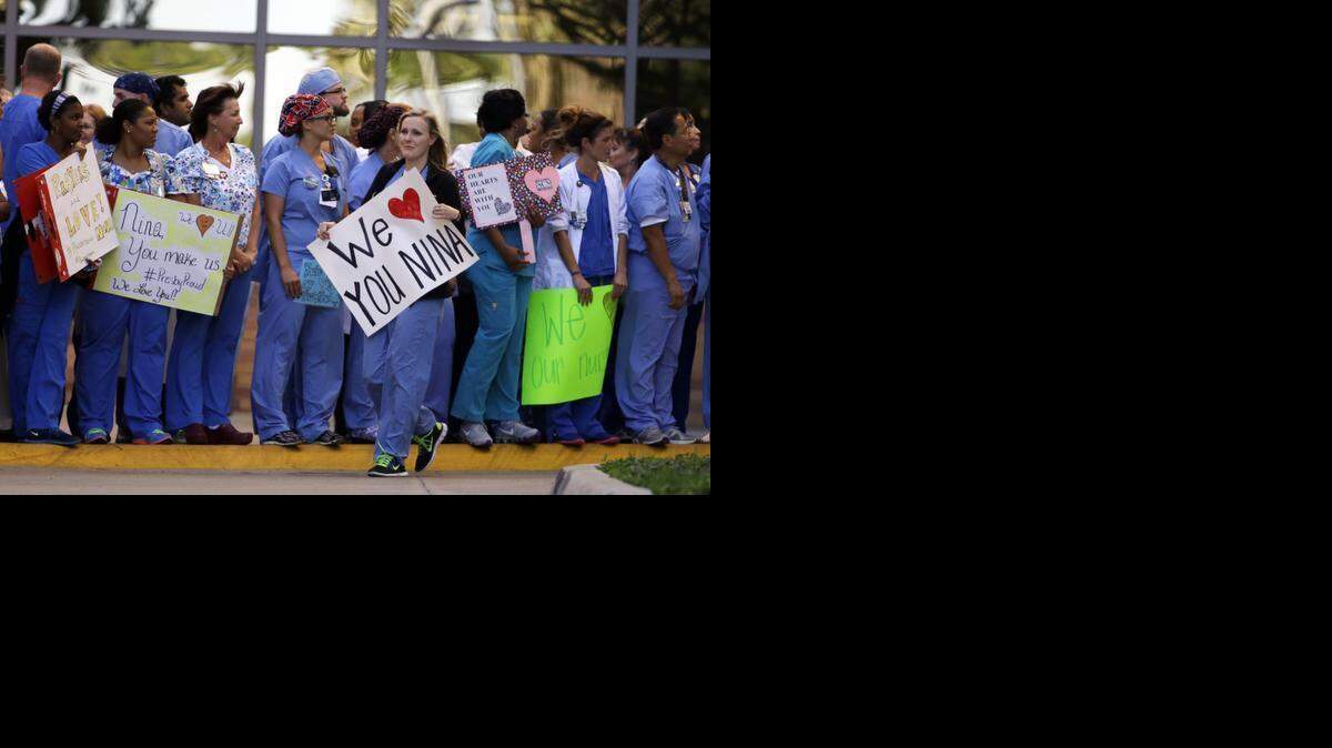 
Texas Health Presbyterian Hospital Dallas staff members lined the drive exiting the emergency room in October when Nina Pham was being transported to be treated for Ebola. 
