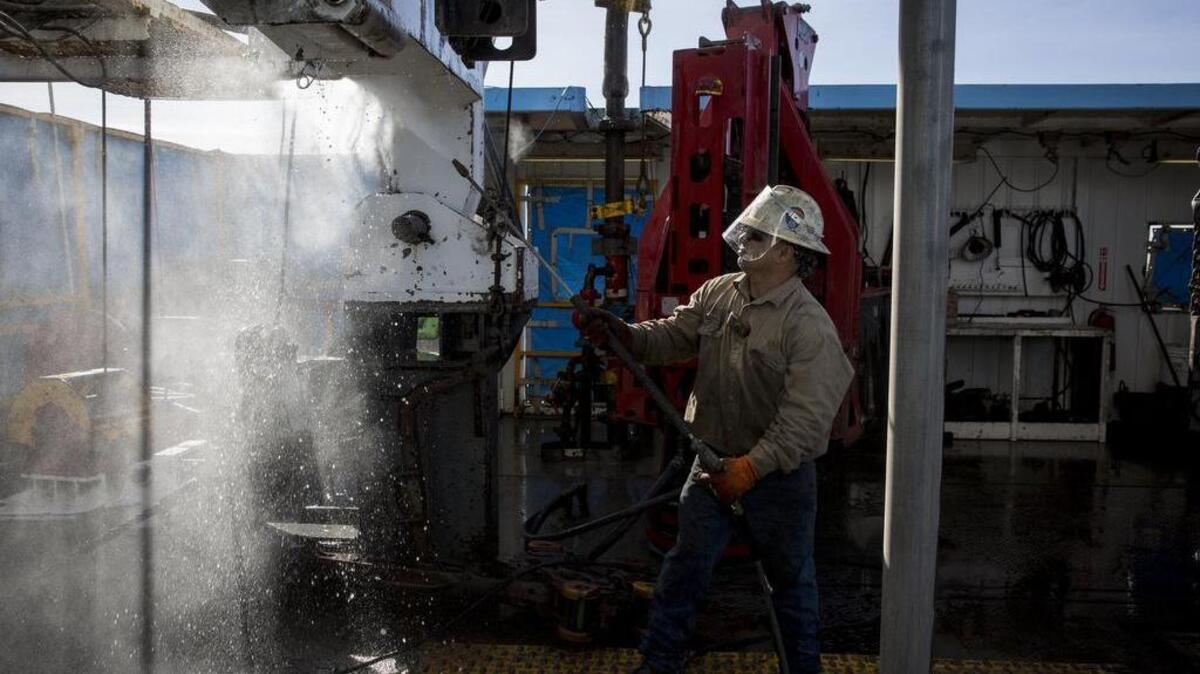 Danny Perez, a floor hand, washes a rig with water in Midland. Job growth has picked up in Texas in 2017.