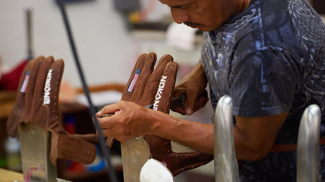 An employee shapes a ball glove on hot steel fingers at the Nokona manufacturing facility in Nocona, north of Fort Worth.