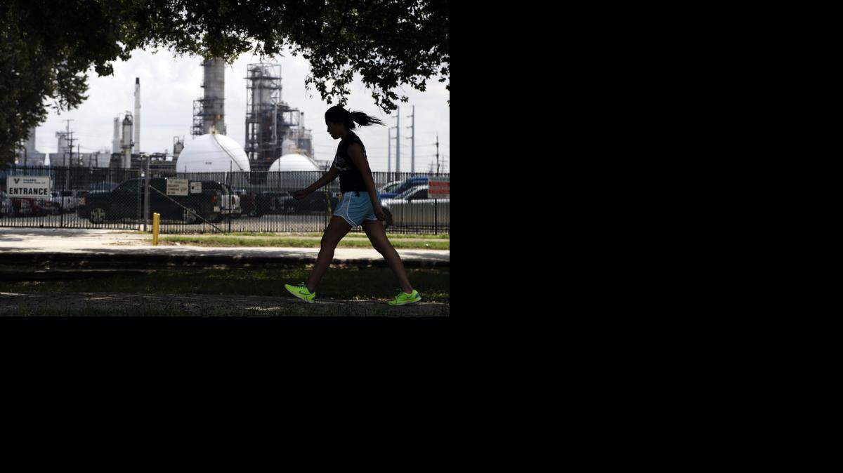
Some states, such as Texas, have diversified their economies since oil prices crashed in the mid-1980s. A teen-age girl walks past the Valero refinery in Houston. 
