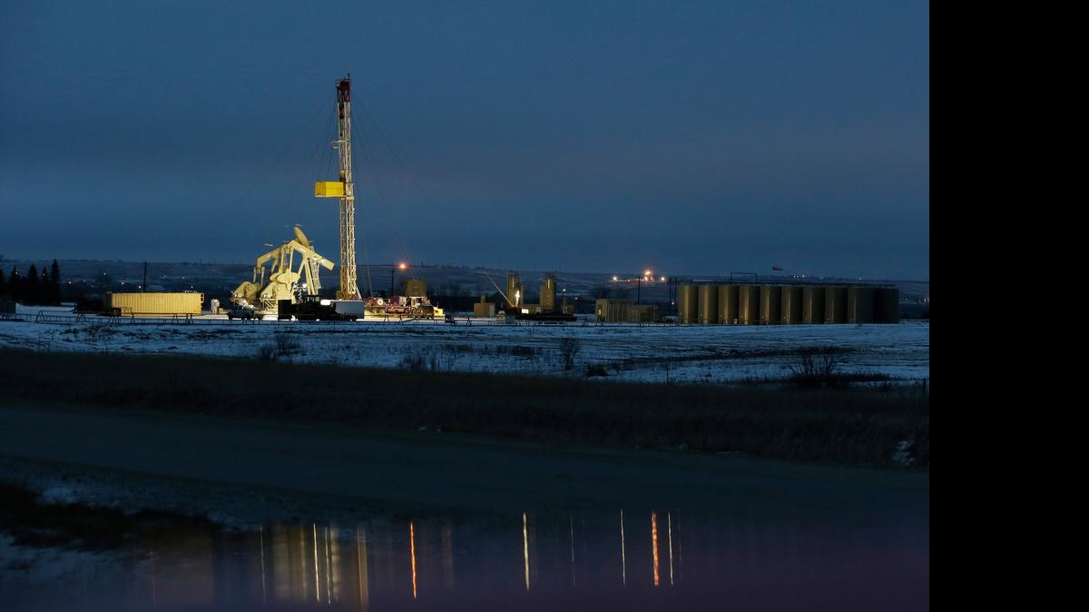 
Lights shine on oil drilling activities, Monday, Dec. 15, 2014, near Williston, N.D. 
