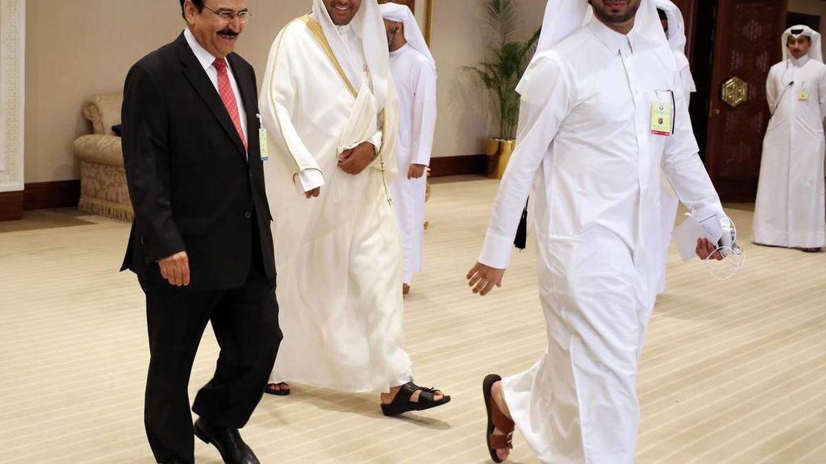 Abdul Hussain bin Ali Mirza, Bahrain's energy minister, left, smiles as he enters an oil-producers' meeting in Doha on Sunday. Oil-producing countries were unable to reach agreement on oil production.