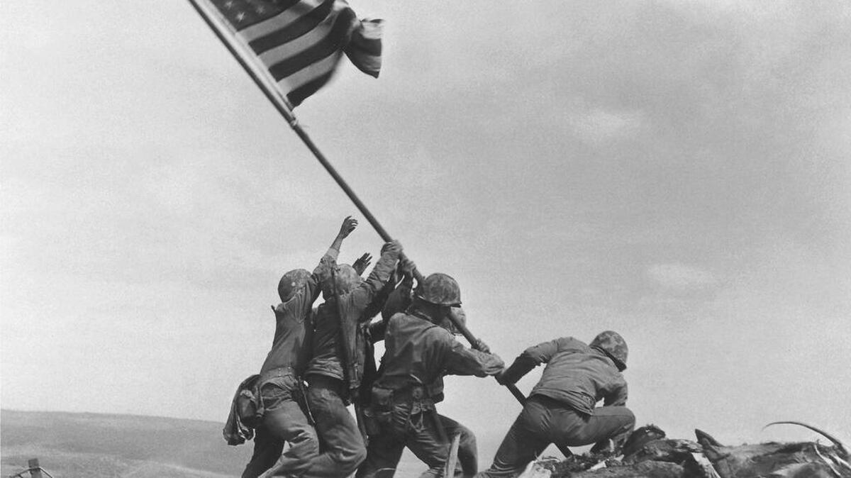 The Marine Corps is considering changing its well-known slogan, The Few. The Proud. The Marines. In this photo Marines raise the American flag atop Mt. Suribachi.
