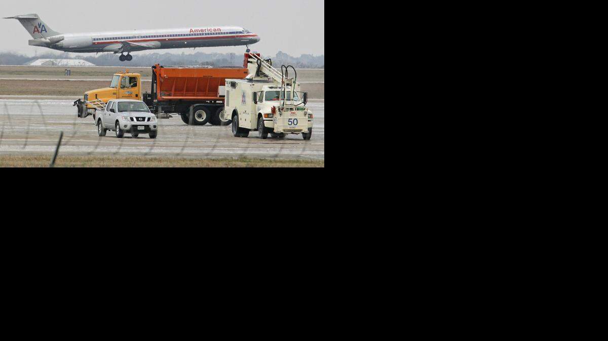 
An American Airlines jet takes off northbound at DFW Airport as a sand truck passes and de-icing trucks stand by as temperatures remained below freezing Tuesday morning.
