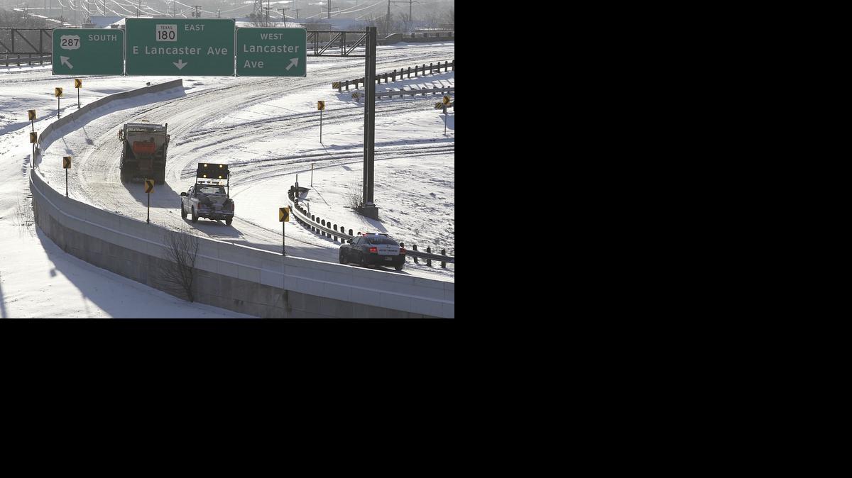 
A sand truck and police unit make their way onto U.S. in heavy snow that covers roadways in Fort Worth early Thursday.

