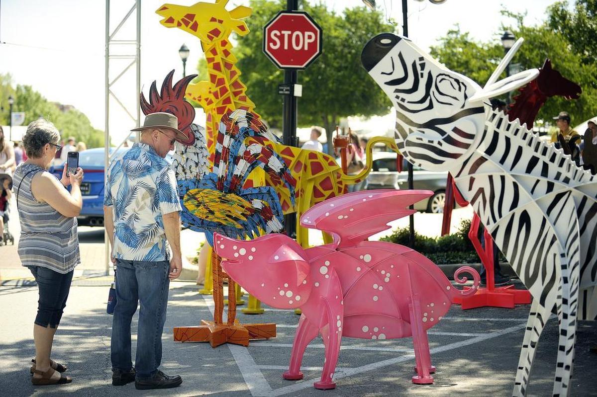 A passer-by checks out Fedrick Prescott’s colorful menagerie at the 17th annual Art in the Square.