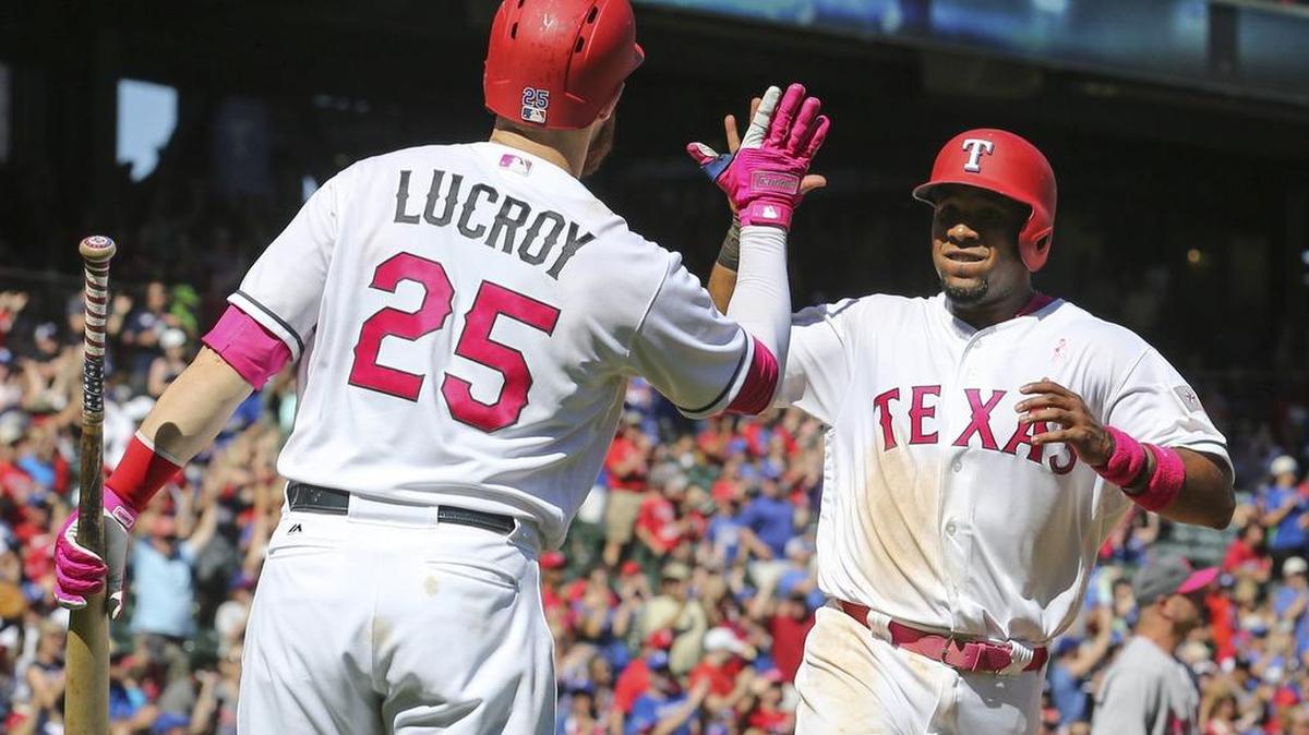 Jonathan Lucroy (25) gives Elvis Andrus a high-five after Andrus scored the go-ahead run Sunday afternoon against the Oakland Athletics at Globe Life Park in Arlington.