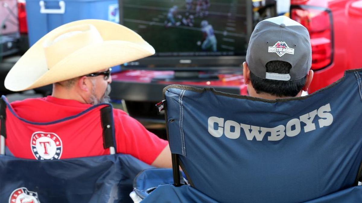 
Benicio Hoyos and Tony Sanchez watch the Dallas Cowboys game as they tailgate before the Rangers game at Globe Life Park in Arlington Sunday.

