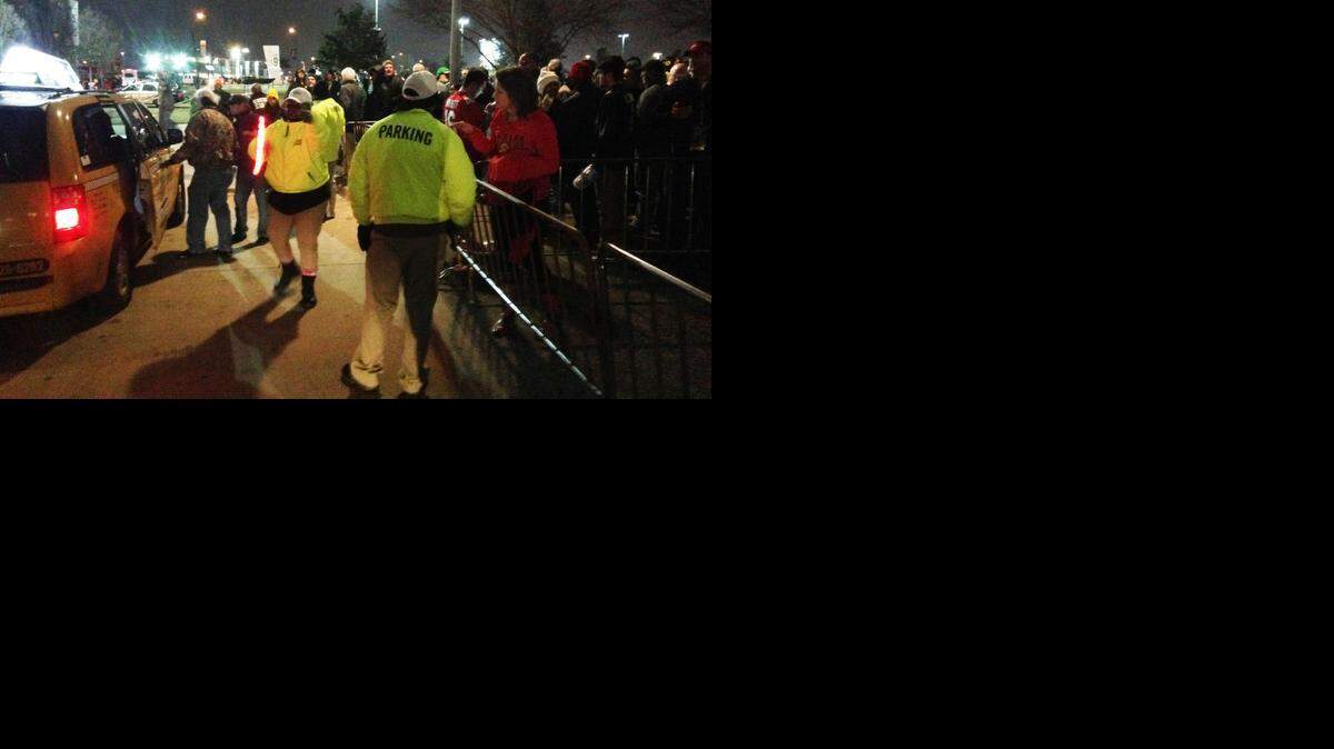 
Parking attendants try to maintain order as the line of people waiting to catch cabs after Monday’s Ohio State-Oregon game grows Monday outside AT&T Stadium in Arlington. 
