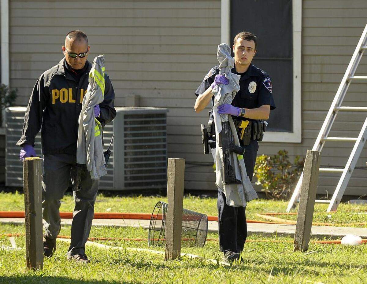 Arlington Police remove to rifles from an apartment where a 2-alarm fire injured at least four people at the Runningbrook Apartments in Arlington.