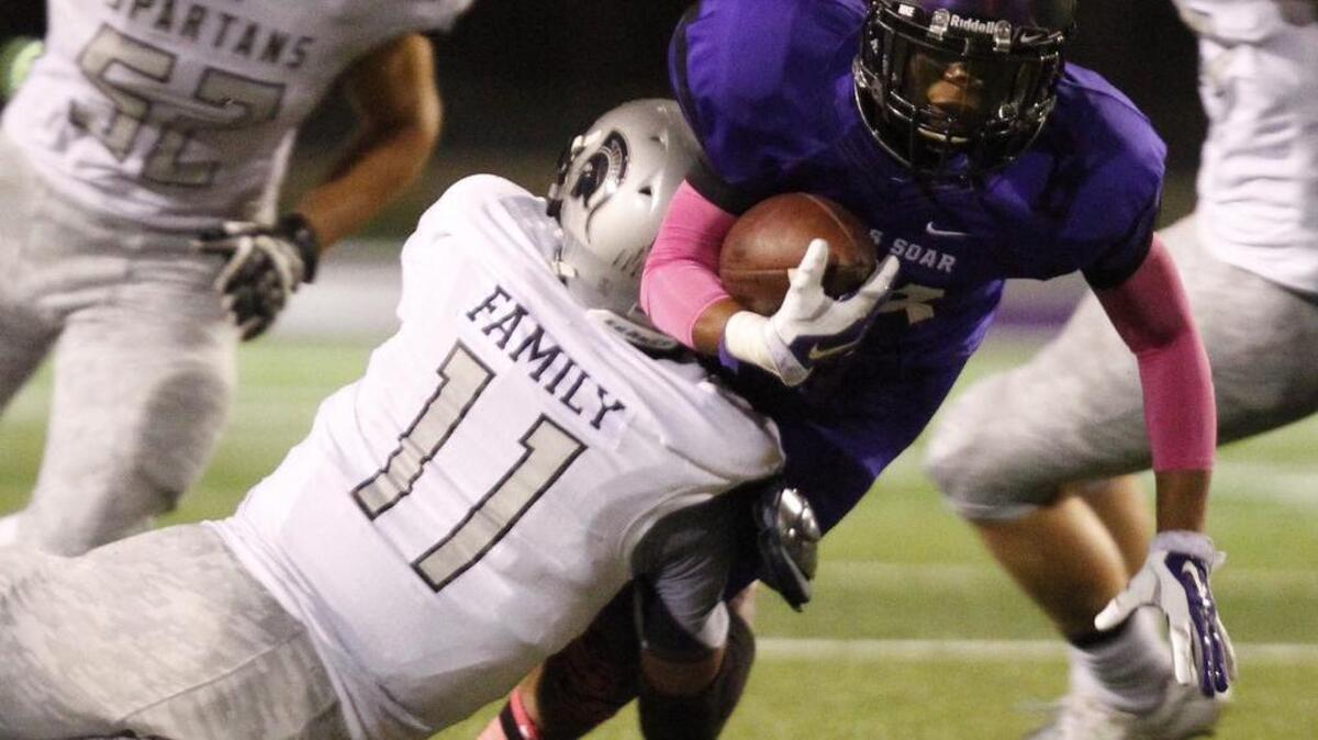 
Hunter Donnelly (11), playing for Burleson Centennial, tackles James Guy of Crowley in a high school football game in October.
