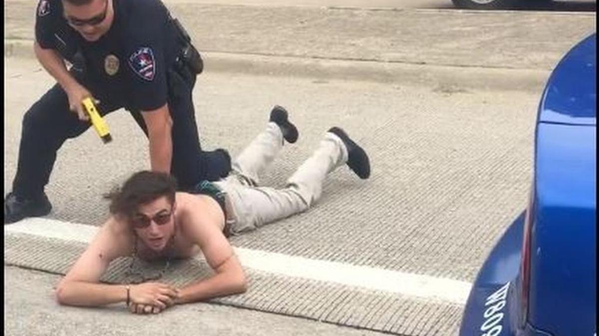 An Arlington police officer on Monday detains a man who claimed affiliation with a terrorist group.
