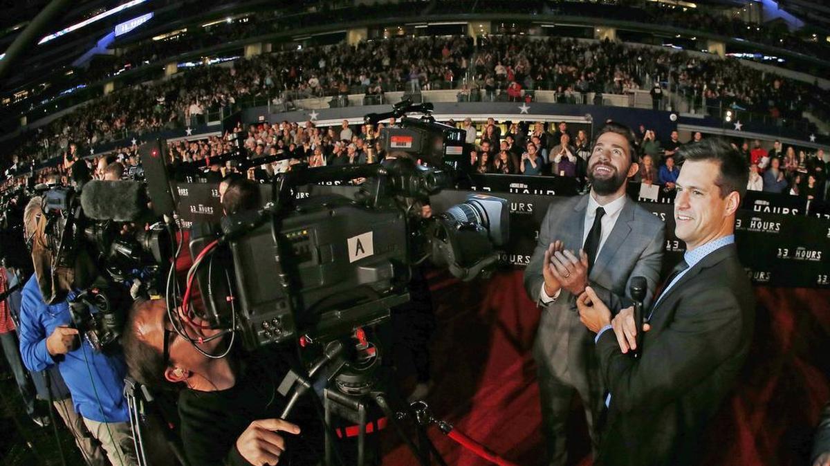 Actor John Krasinski watches a clip of ‘13 Hours’ on AT&T Stadium’s giant screen during an interview with an entertainment reporter from Los Angeles on Tuesday, Jan. 12, 2016.