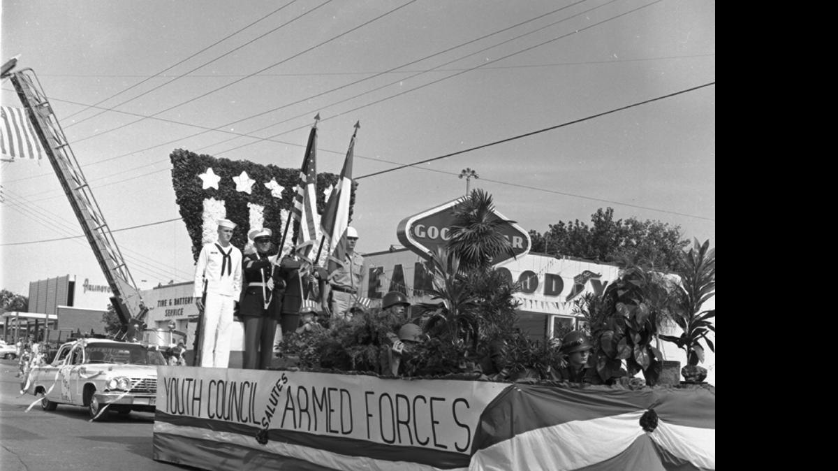
A float passes underneath a U.S. flag suspended from firetruck ladders in the 1966 Arlington July Fourth parade. Some 5,000 people lined the route from Ousley Junior High, down Abram Street to Center Street, then Main Street to the Central Fire Station. Randol Mill Park was site of the concluding program, games, chicken lunch and bell-ringing ceremony. 
