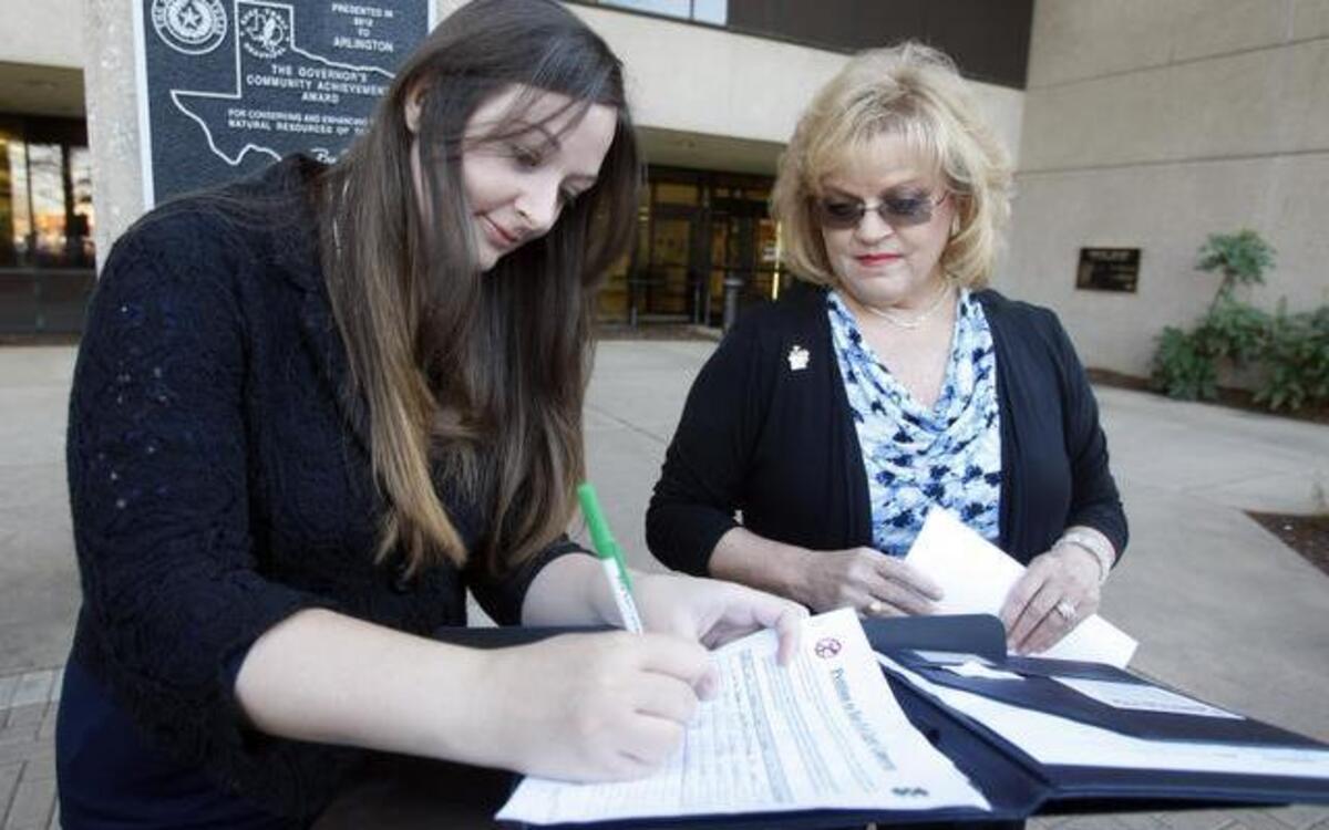 
Faith Bussey, left, and Kelly Canon prepare to turn in signatures on a petition to ban red light cameras in Arlington on Tuesday, Jan. 20, 2015. 
