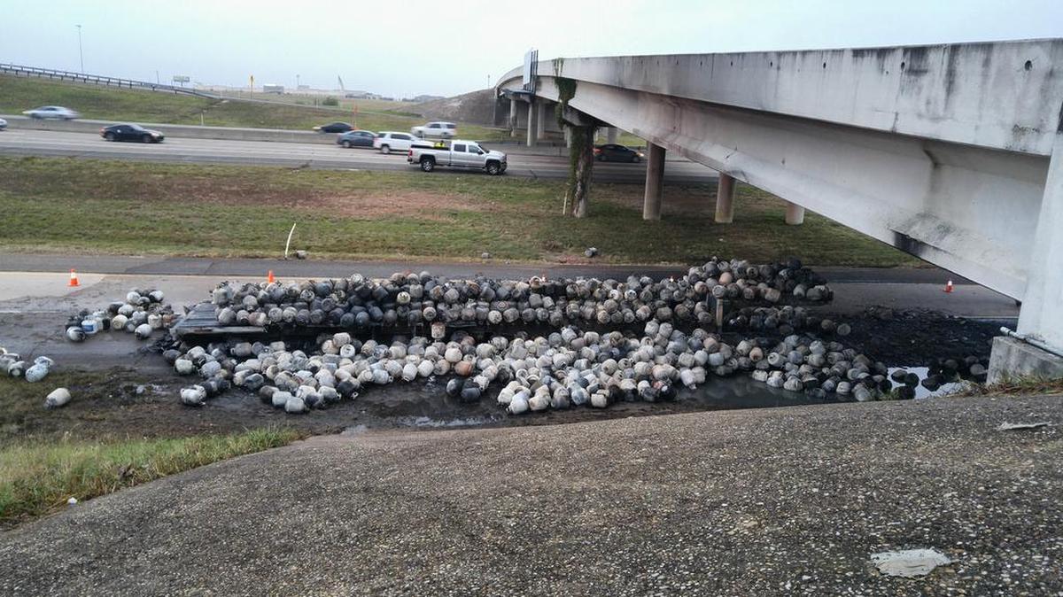 Hundreds of burned-out propane tanks lie on and around a trailer on Texas 360 after they burst into flames and damaged the Bardin Road bridge, which has been closed since the early November incident.