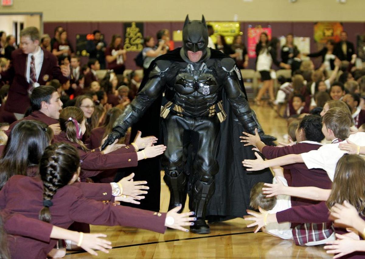 Students reach out to high-five Bat Man, aka officer Damon Cole of Heroes and Cops Against Childhood Cancer, during a Go Gold pep rally at IL Texas Keller in 2016.