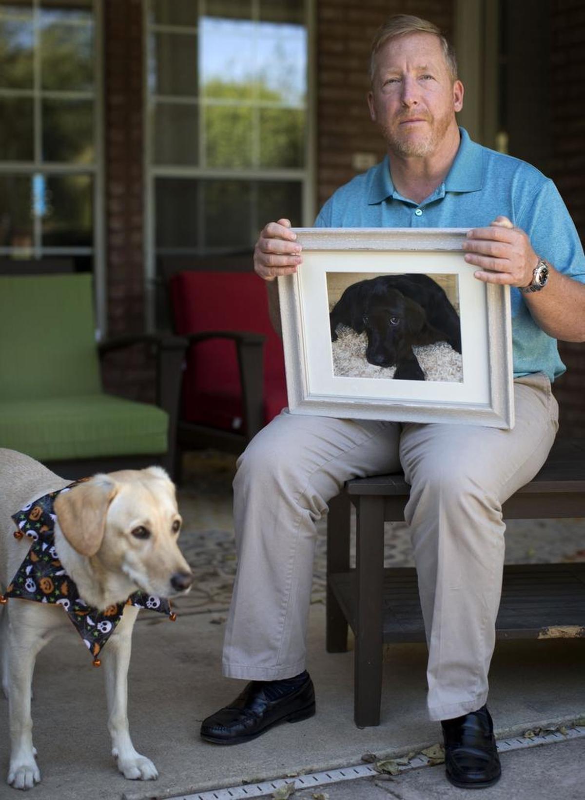 Haeger Long holds a picture of his dog, Lola, who died in February from what he calls a tragic accident. Prosecutors dismissed an animal cruelty charge against Long on Wednesday.
