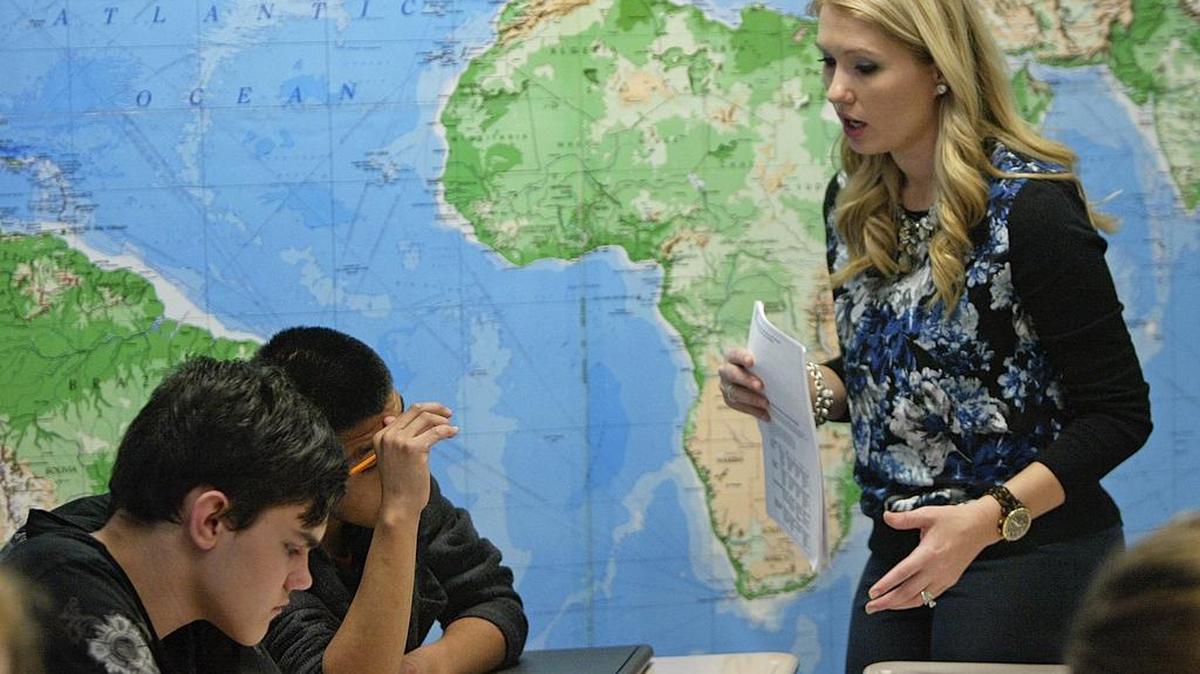 Sarah Thompson helps Jonathon Skea, 14, and George Sosa, 15, in class.